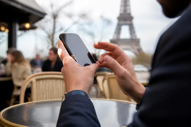 Main d'une personne à Paris utilisant une application de portefeuille crypto sur son smartphone, illustrant la simplicité de gestion des actifs numériques.