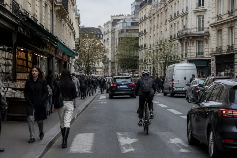 Une scène de rue animée à Paris, avec des cyclistes et des piétons, symbolisant la diversité des environnements d'application de la blockchain.