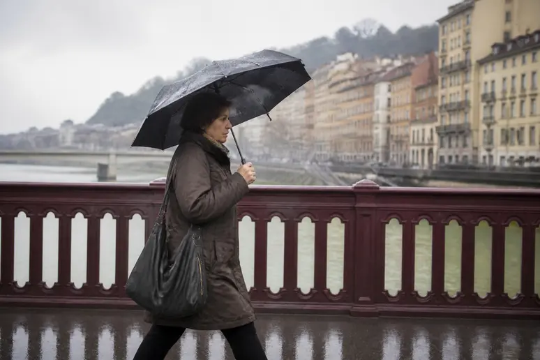 Une Lyonnaise marche d'un pas décidé sur un pont, l'air pensif, symbolisant la gestion des aléas du marché boursier.