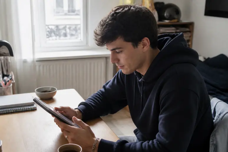 Jeune homme français évaluant les boursorama pea frais pour son PEA-Jeunes.