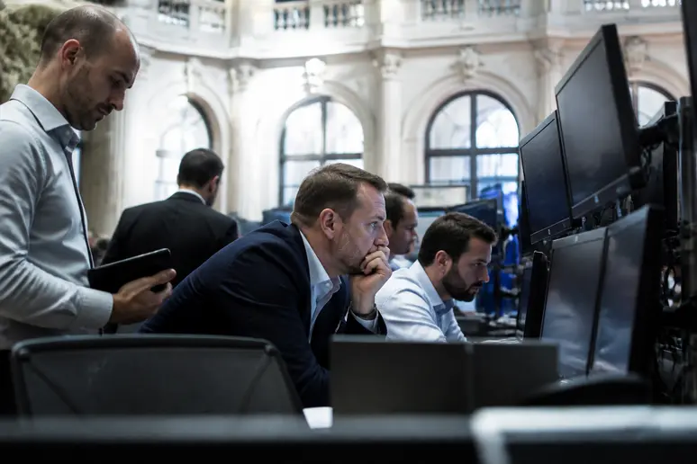 Traders au cœur des risques d'investissement cardano crypto, analysant des graphiques financiers complexes.