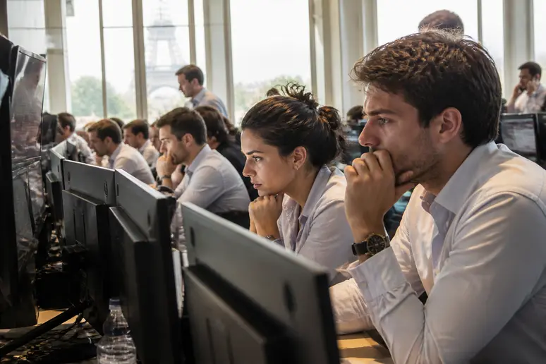 Des traders concentrés sur leurs écrans dans un bureau parisien, le day trading c'est quoi au cœur de l'action.