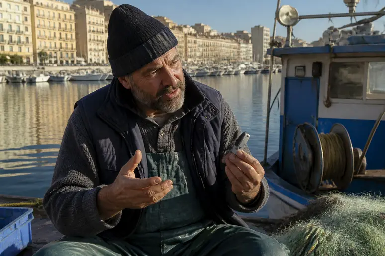 Un pêcheur marseillais examine un portefeuille matériel de cryptomonnaies devant son bateau, illustrant la sécurisation des actifs numériques.