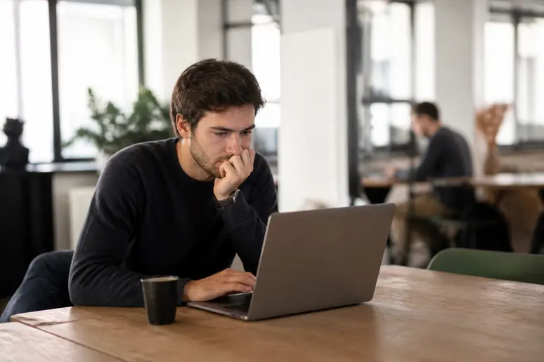 Jeune homme analysant des graphiques boursiers, clé du swing trading débutant.