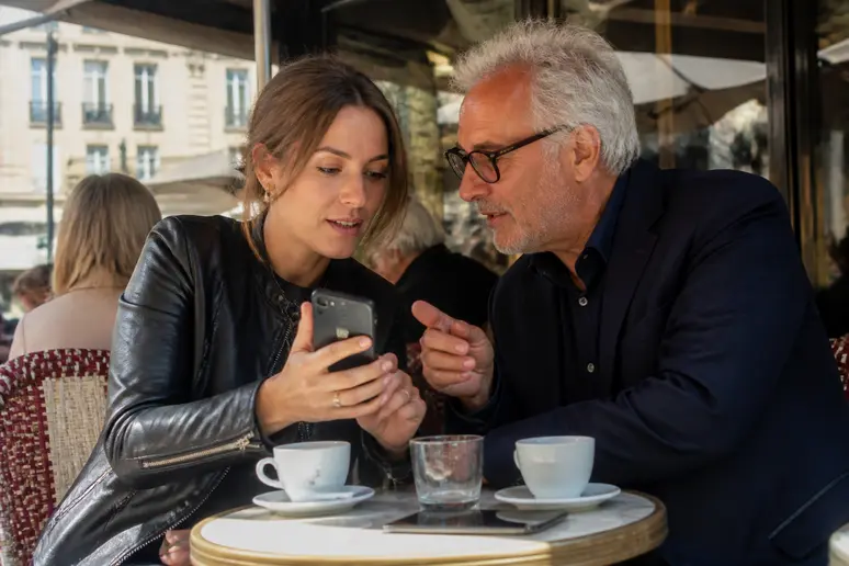 Une jeune Parisienne explique son application de portefeuille crypto à un ami lors d'une discussion animée dans un café typique de la capitale.