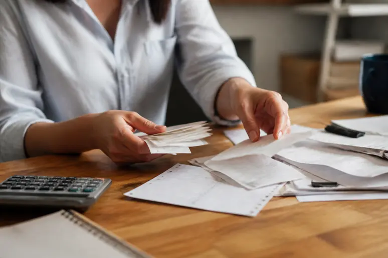 Entrepreneur individuel triant des documents comptables pour ses obligations bancaires professionnelles