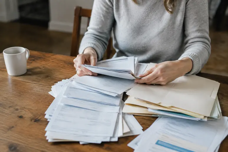 Personne triant des relevés et des documents financiers pour préparer sa déclaration de compte Binance.