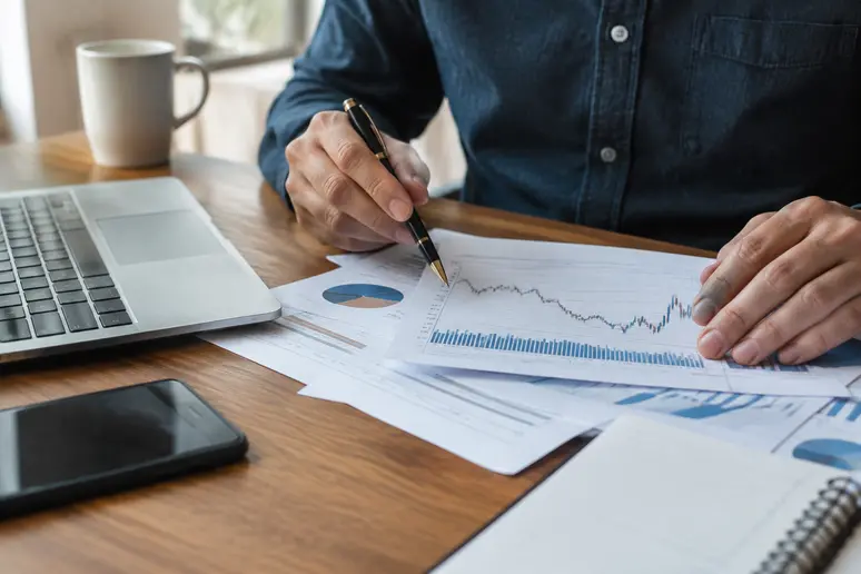 Investisseur analysant ses relevés de portefeuille et le dividende credit agricole sur ses documents financiers