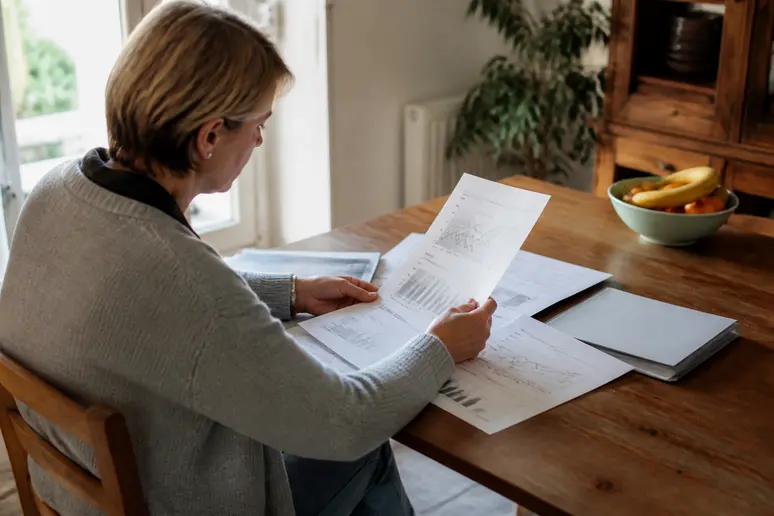 Un investisseur examine les documents de son plan d'épargne en actions lors de démarches administratives.
