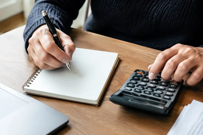 Notes financières et calculatrice pour évaluer le ticket d'entrée d'un PEA en gestion pilotée